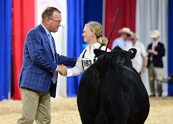 Zoe receiving congratulations from Dr. Allen Miller, show judge.
